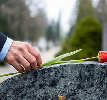 Detail van een opstaande grafsteen met bloem
